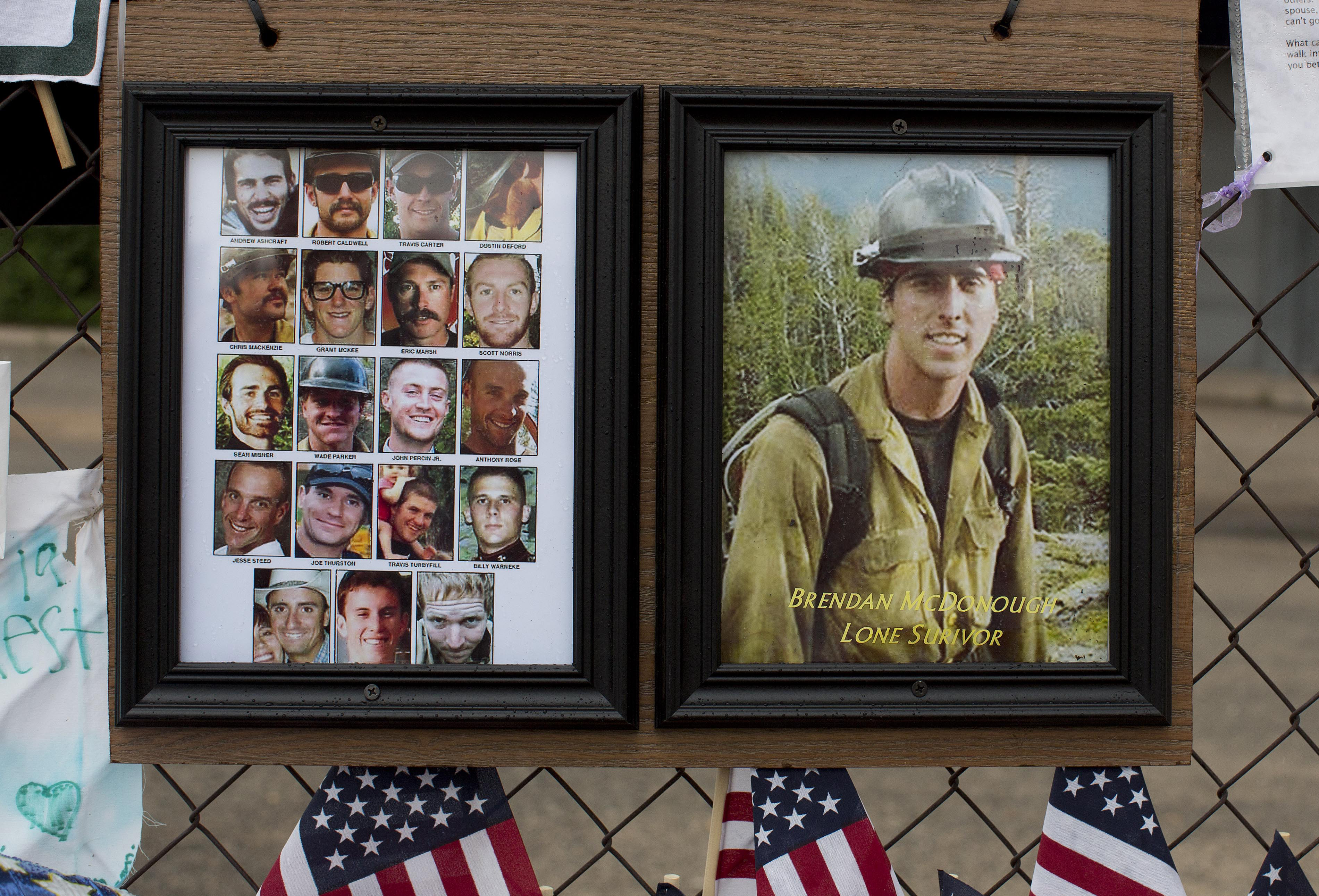 Photos of the 19 fallen Granite Mountain Hotshot firefighters and the lone survivor of the fatal blaze hang on the fence outside Fire Station No. 7, Friday, July 5, 2013 in Prescott, Ariz.