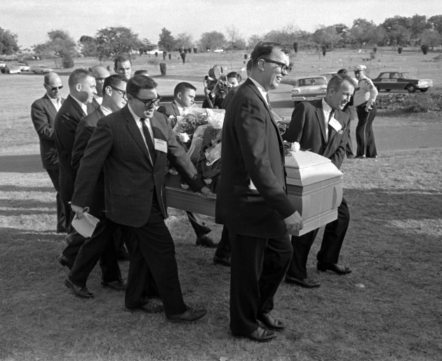 Reporters were enlisted to act as pall bearers at the interment of Lee Harvey Oswald at the Shannon Rose Hill Cemetery. Pallbearers from left end - Jerry Flemmons with crewcut and no glasses. In front of Flemmons are reporters Ed Horn and Mike Cochran. Funeral director Paul J. Groody was among the pallbearers. On the far side of the casket are Jon McConal, rear, and Preston McGraw, front. The pallbearer obscured behind Groody could not be identified. (AP Photo/Gene Gordon)