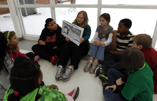 Joyce Cook, and instructional aide, reads Snowflake Bentley to a group of 5th graders stranded at Oak Mountain Intermediate school due to snow and ice on Tuesday, Jan. 28, 2014, in Indian Springs, Ala. (AP Photo/Butch Dill)
