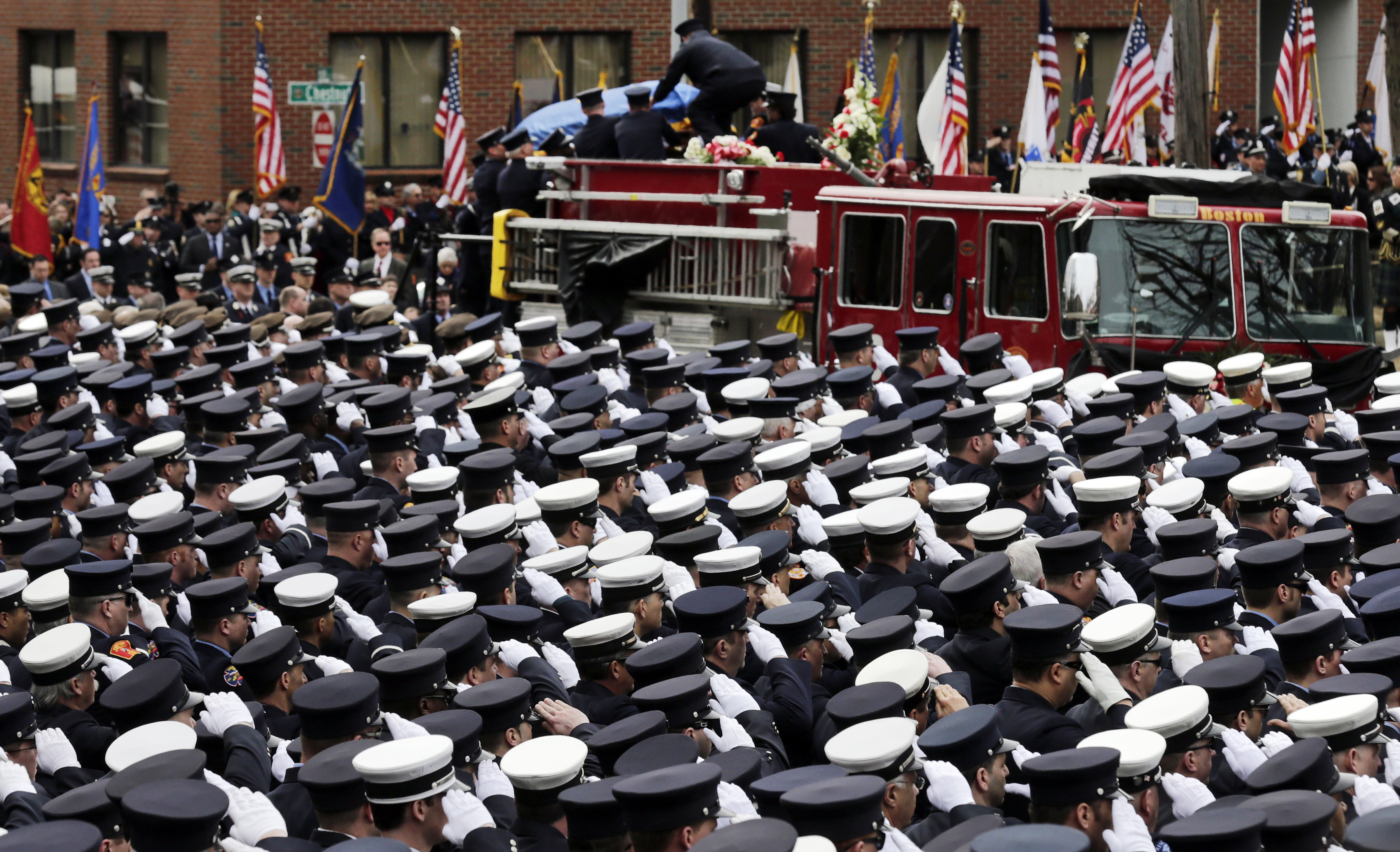 Firefighters salute as the casket of Boston fire Lt. Edward Walsh is lowered from Engine 33 as the funeral procession arrives outside St. Patrick's Church in Watertown, Mass., Wednesday, April 2, 2014. Walsh and his colleague Michael Kennedy died after being trapped while battling a nine-alarm apartment fire in Boston on March 26. (AP Photo/Charles Krupa)