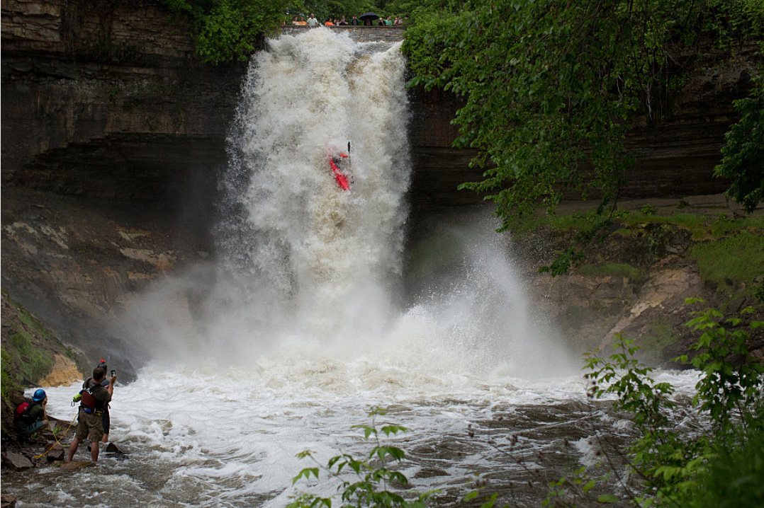 Professional kayaker Hunt Jennings goes over Minnehaha Falls Thursday in Minneapolis. Watching his descent were members of his safety crew, including Shane Brink, Josh Fischer and Tony Locken. Jennings is from Chattanooga, Tenn. Jennifer Simonson/MPR News