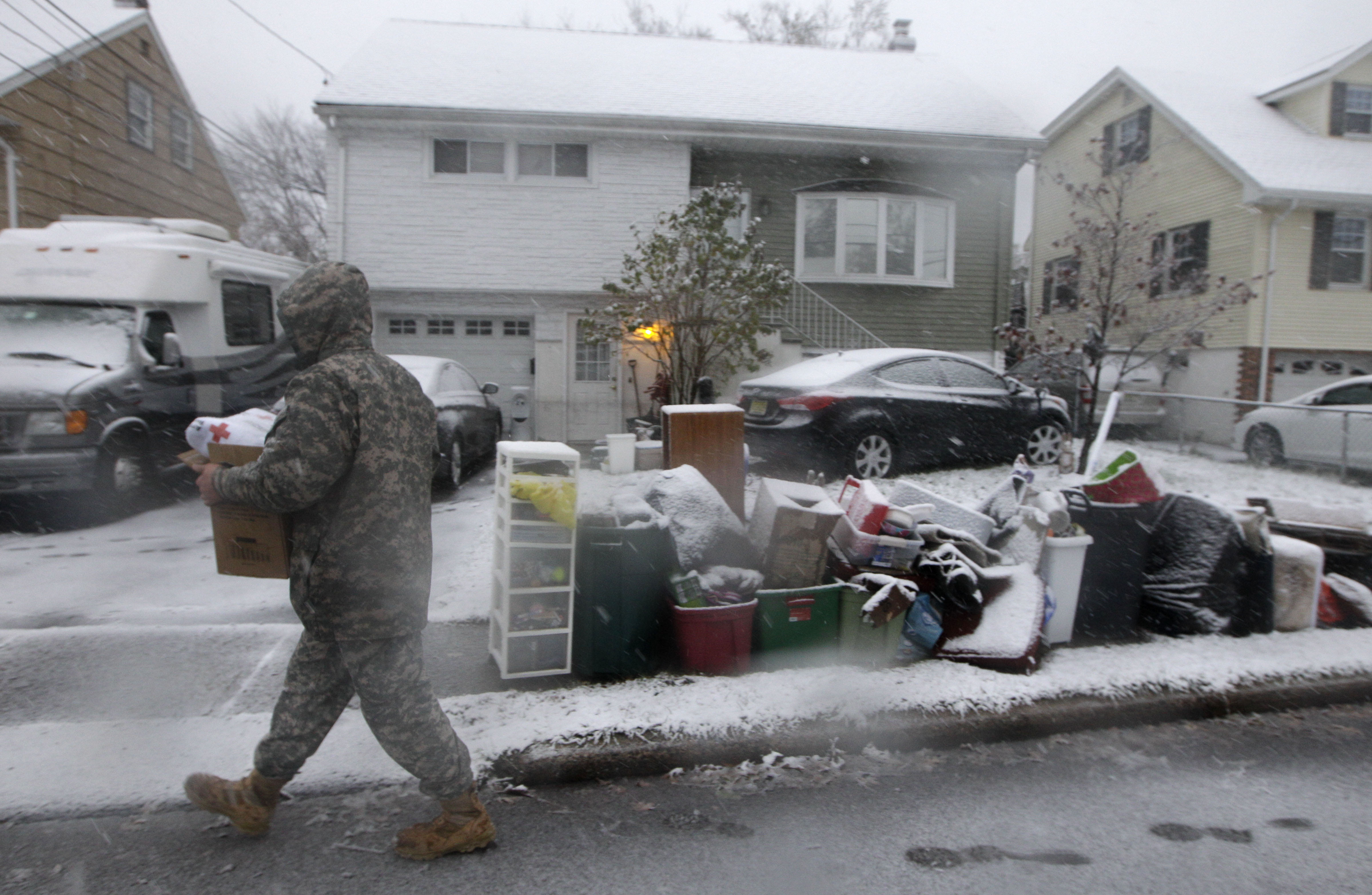 National Guardsman Brandon Kyle, left, goes door-to-door offering blankets donated by the American Red Cross to residents of Little Ferry, N.J., a neighborhood that was flooded by Superstorm Sandy as a Noreaster approached, Wednesday, Nov. 7, 2012. (AP Photo/Kathy Willens)
