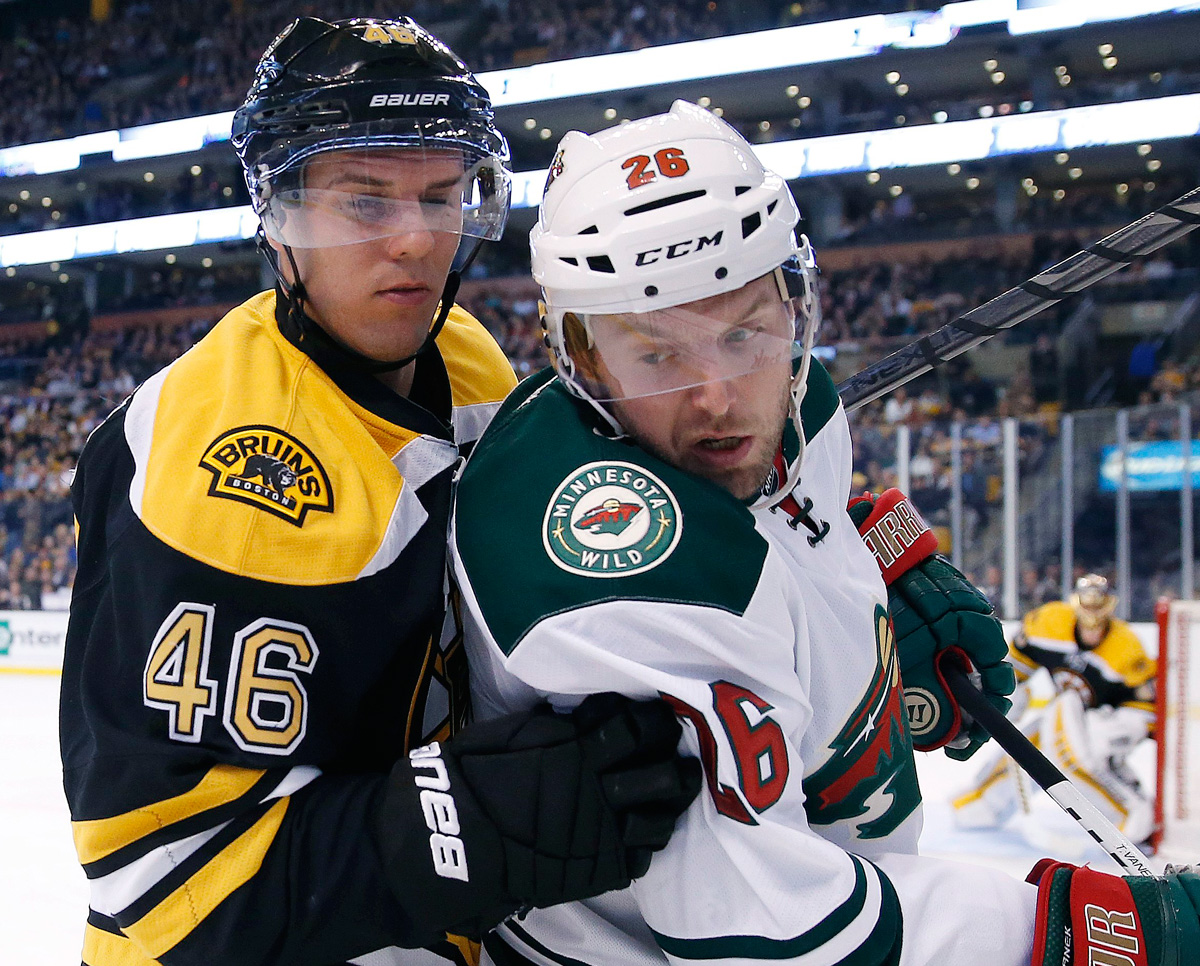 Boston Bruins' David Krejci  and Minnesota Wild's Thomas Vanek  battle for the puck in the first period of an NHL hockey game in Boston, Tuesday, Oct. 28, 2014. (AP Photo/Michael Dwyer)