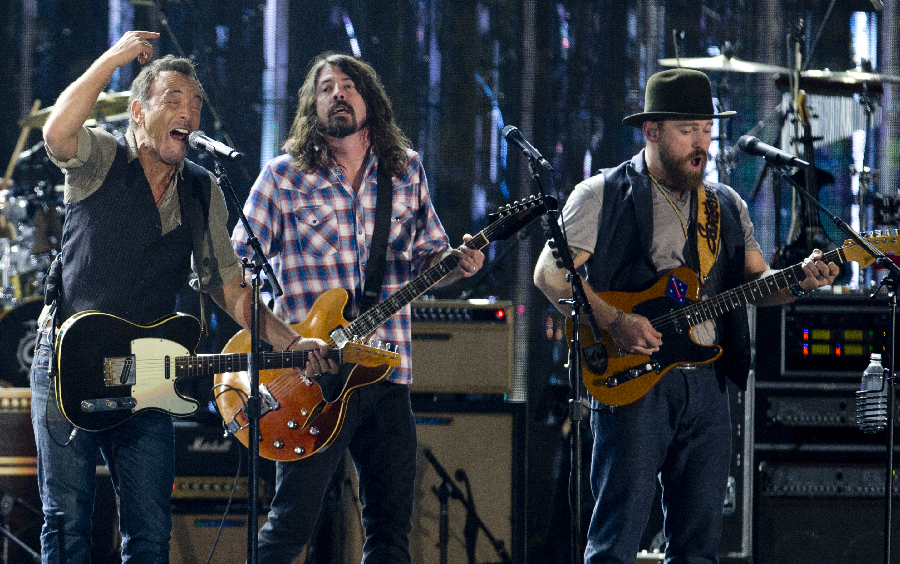 From left, Bruce Springsteen, Dave Grohl, and Zac Brown, sing on the National Mall in Washington, Tuesday, Nov. 11, 2014, during the Concert for Valor. The Veterans Day event is hosted by HBO, Starbucks and Chase and is free and open to the public. (AP Photo/Carolyn Kaster)