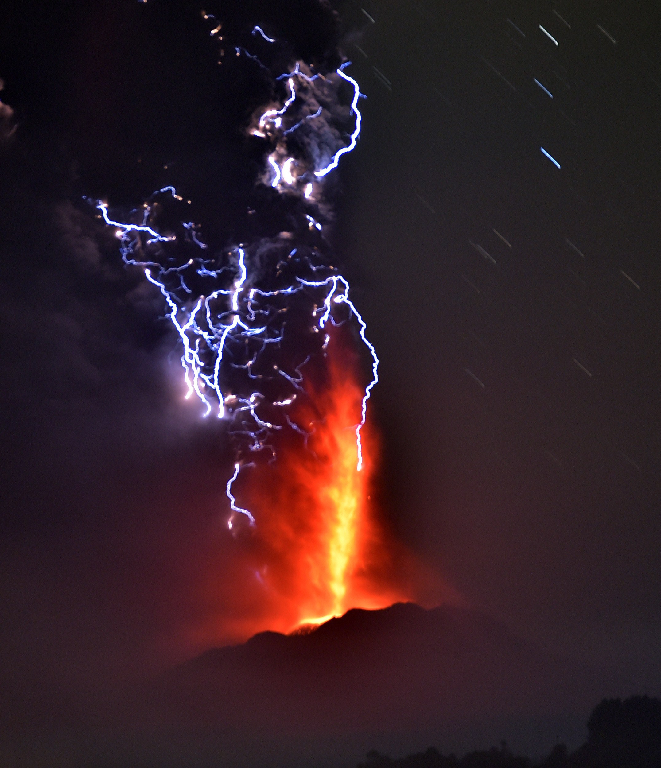 View from Frutillar, southern Chile, showing volcanic lightnings and lava spewed from the Calbuco volcano on April 23, 2015. Chile's Calbuco volcano erupted on Wednesday, spewing a giant funnel of ash high into the sky near the southern port city of Puerto Montt and triggering a red alert. Authorities ordered an evacuation for a 10-kilometer (six-mile) radius around the volcano, which is the second in southern Chile to have a substantial eruption since March 3, when the Villarrica volcano emitted a brief but fiery burst of ash and lava. AFP PHOTO/MARTIN BERNETTI/Getty Images.