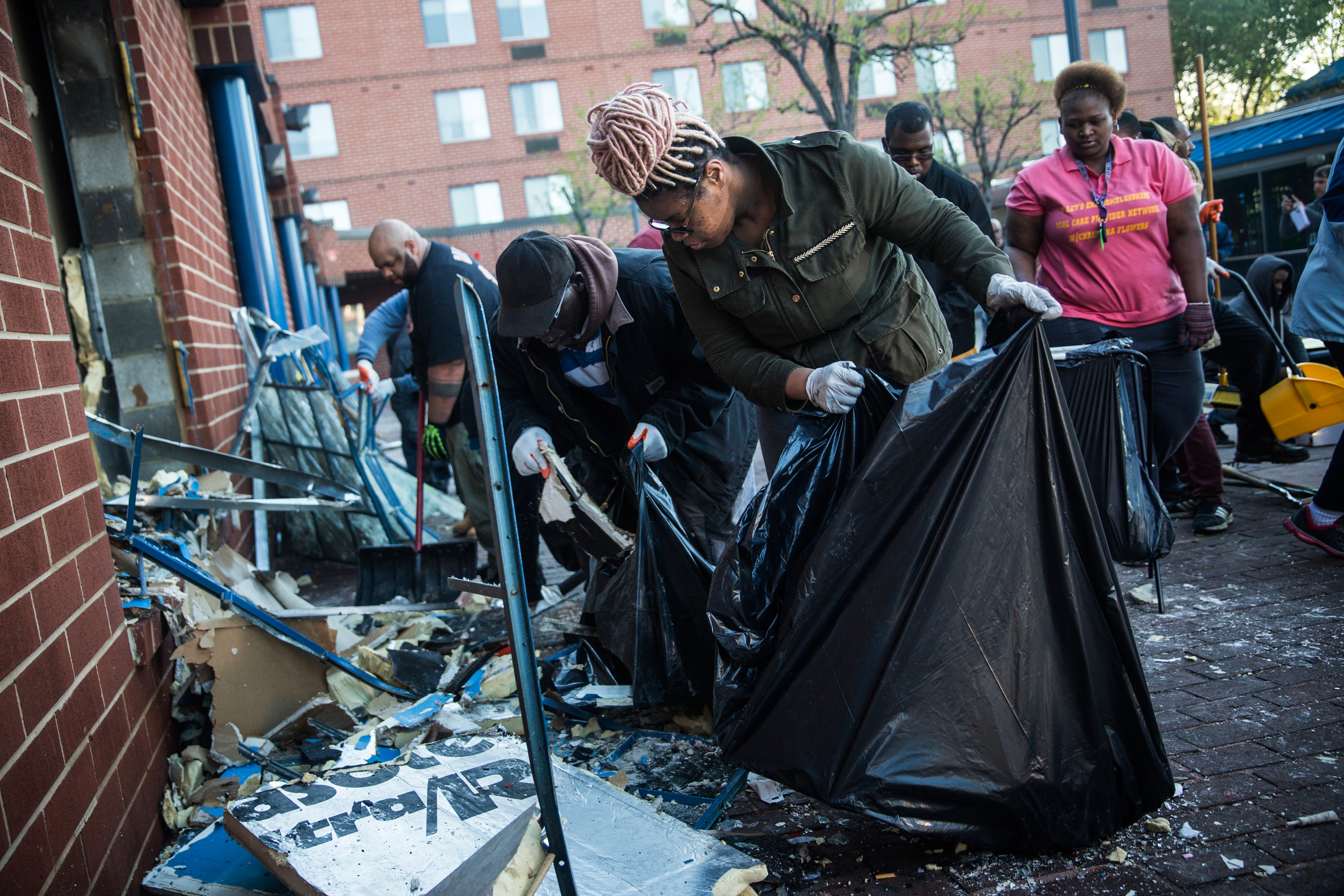 BALTIMORE, MD - APRIL 28:  Members of the community clean up debris from a CVS pharmacy that was set on fire yesterday during rioting after the funeral of Freddie Gray, on April 28, 2015 in Baltimore, Maryland. Gray, 25, was arrested for possessing a switch blade knife April 12 outside the Gilmor Houses housing project on Baltimore's west side. According to his attorney, Gray died a week later in the hospital from a severe spinal cord injury he received while in police custody.  (Photo by Andrew Burton/Getty Images)