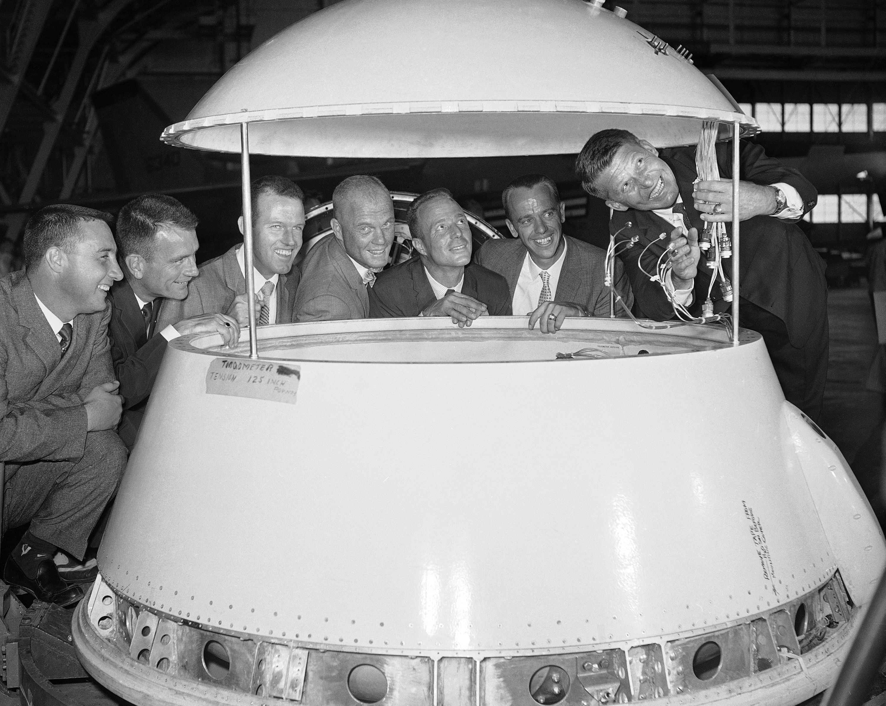 Seven astronauts in training at Langley Research Center, Va., pose on July 7, 1959, with a model of the capsule one of them may ride into space in 1961. From Left to right are Air force Capt. Virgil Grissom, Air Force Capt. Donald Slayton, Air Force Capt. Beroy Cooper, Marine Lt. Col. John Glenn, Navy Lt. Malcolm Carpenter, Navy Lt. Cmdr. Alan Shapard and Navy Lt. Cmdr. Walter Schirra. (AP Photo/CPG)