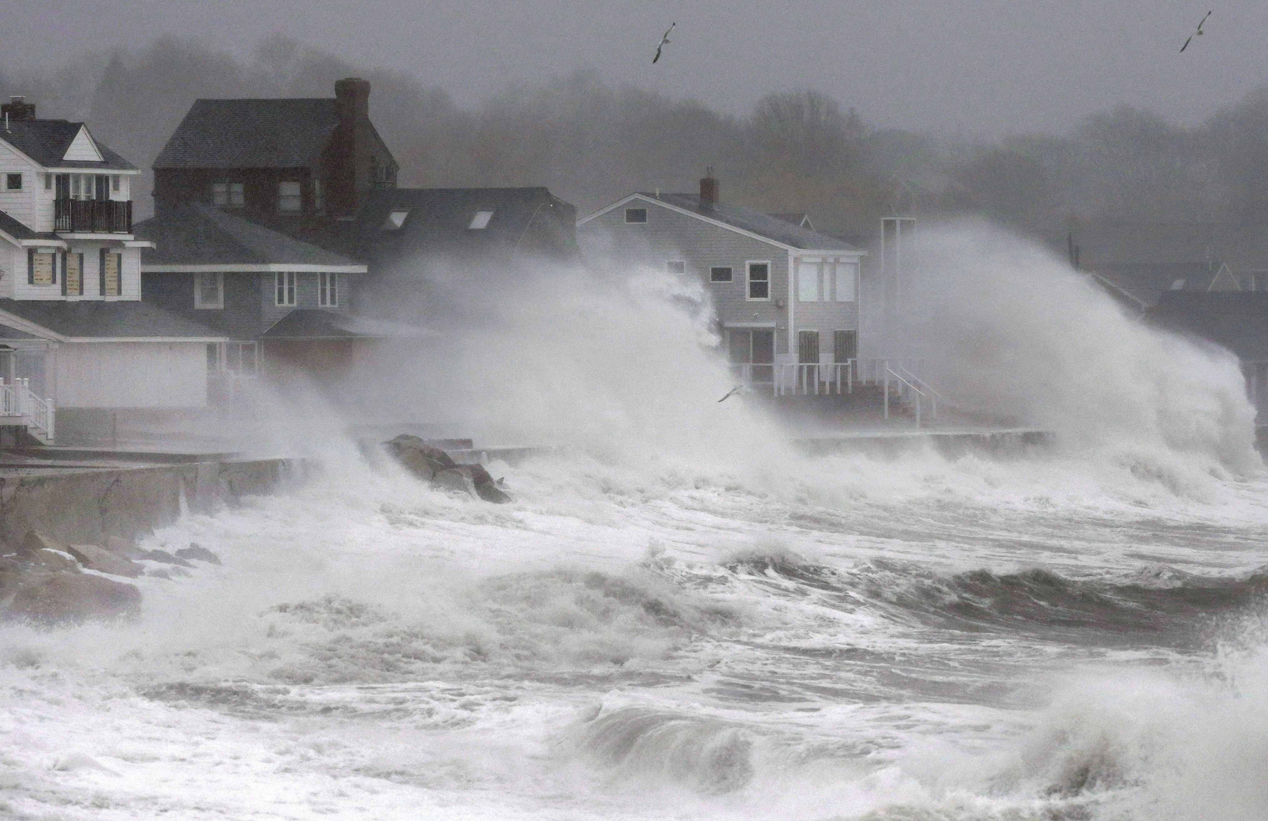 Waves splash against a seawall and onto houses along the Atlantic coast, Tuesday, Dec. 9, 2014, in Scituate, Mass.  AP Photo/Steven Senne.