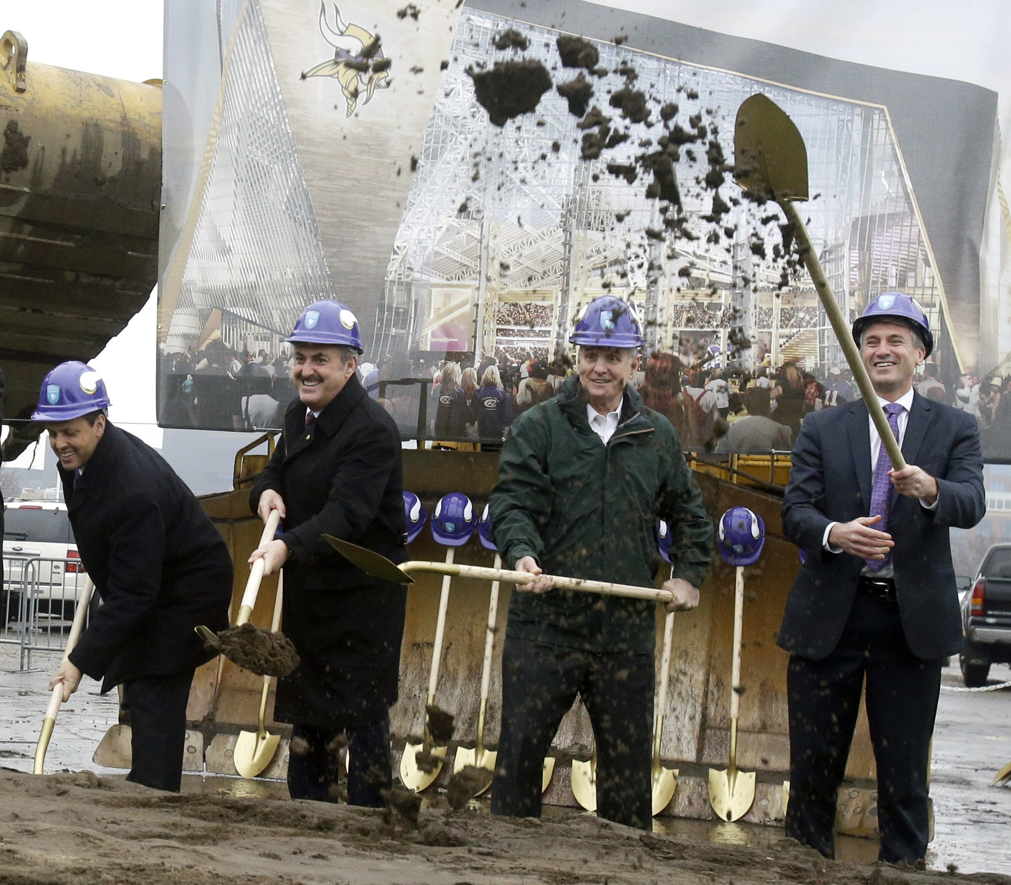 A large rendering of the new Minnesota Vikings football stadium stands behind Vikings owners Mark, left, and  Zygi Wilf, second from left, as they are joined by Gov. Mark Dayton, second from right, and Minneapolis Mayor R.T. Rybak during one of several ceremonial dirt tosses at groundbreaking ceremonies for the new Minnesota Vikings NFL football stadium, Tuesday  Dec. 3, 2013, in Minneapolis. AP Photo/Jim Mone)