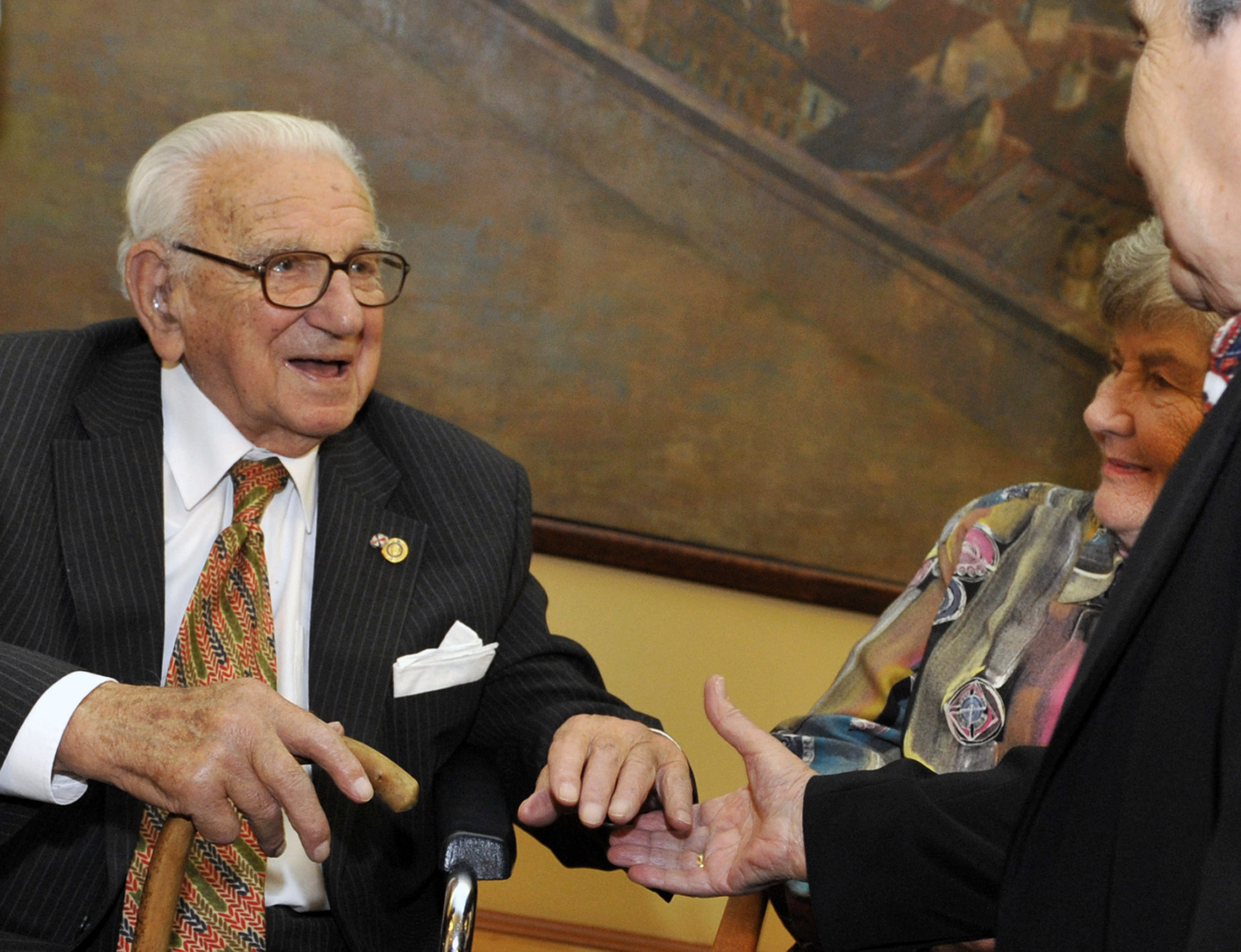 Sir Nicholas Winton, left, who had organized the rescue of 669 mainly Jewish children by train from Prague in 1939, shakes hand with one of them during their meeting with Czech Defense Minister Alexandr Vondra, not seen,  in Prague, Czech Republic, Friday, Jan. 21, 2011. (AP Photo,CTK/Roman Vondrous) **SLOVAKIA OUT**