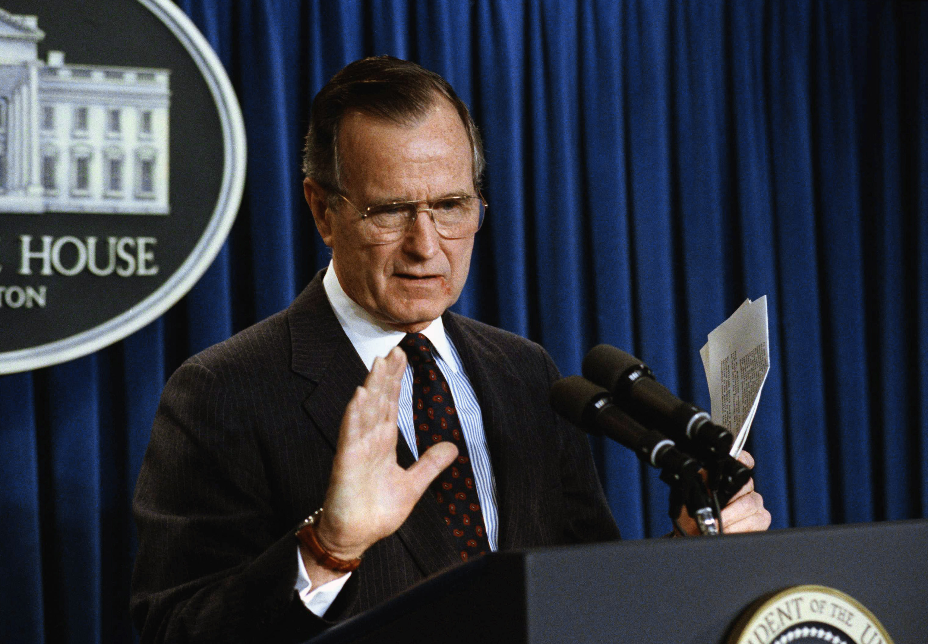 U.S. President George H. Bush gestures while speaking to reporters in the White House in Washington, Monday, Dec.17, 1990. Bush said he still hopes for talk with Iraq on resolving the Persian gulf crisis, but said Iraqi forces must be out of Kuwait by January 15, "and that means entirely." Bush would not say what he'd do if the headline wasn't met. (AP Photo/Marcy Nighswander)