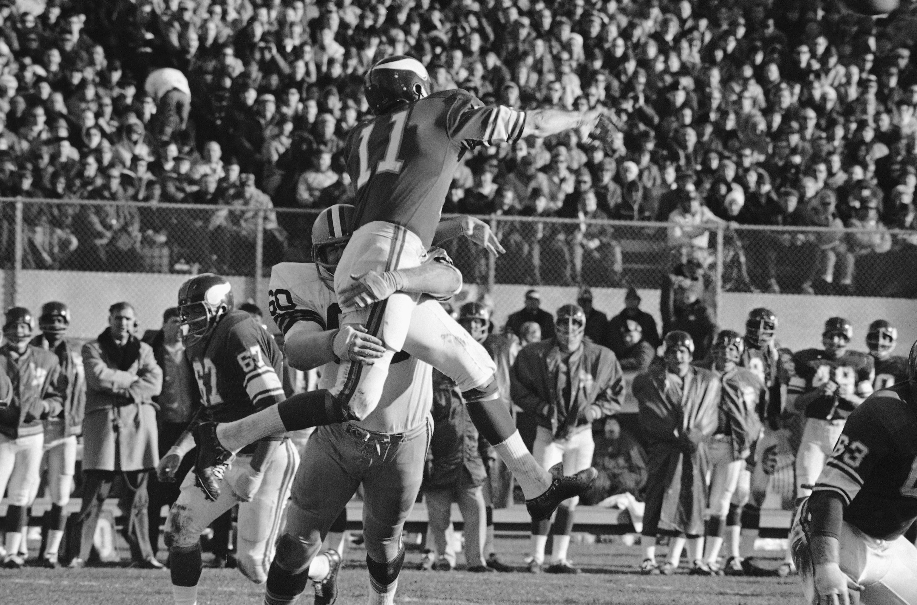 Minnesota Viking quarterback Joe Kapp is lifted high into the air by Green Bay Packers' Lee Roy Caffey (60) after pass by Kapp in first half of National Football League game in Twin Cities on Sunday, Dec. 3, 1967 in Minneapolis. Pass went incomplete. (AP Photo)