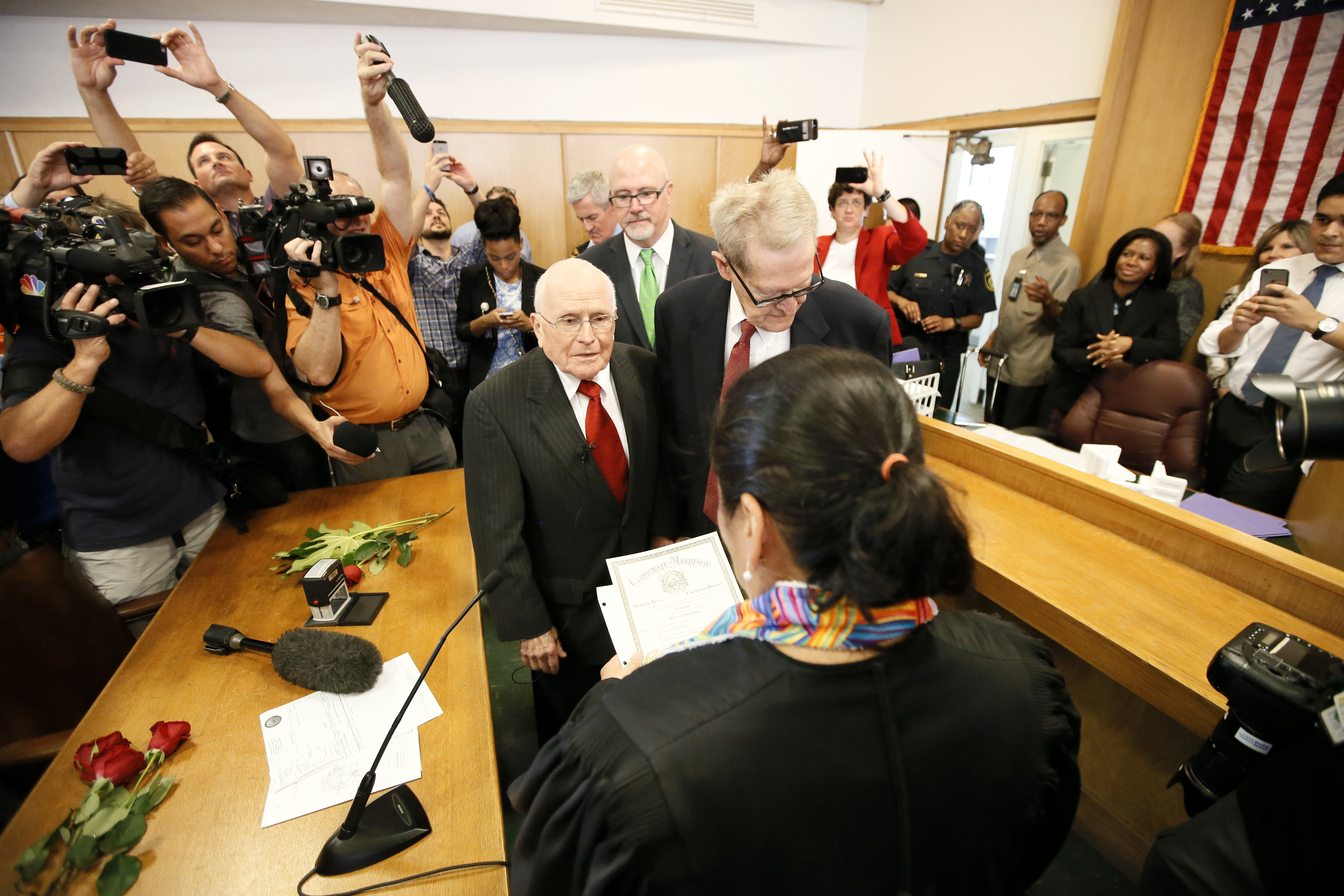 Judge Dennise Garcia, front, performs a marriage ceremony for George Harris, 82, center left, and Jack Evans, 85, center right, Friday, June 26, 2015, in Dallas. Gay and lesbian Americans have the same right to marry as any other couples, the Supreme Court declared Friday in a historic ruling deciding one of the nation's most contentious and emotional legal questions. Celebrations and joyful weddings quickly followed in states where they had been forbidden. (AP Photo/Tony Gutierrez)