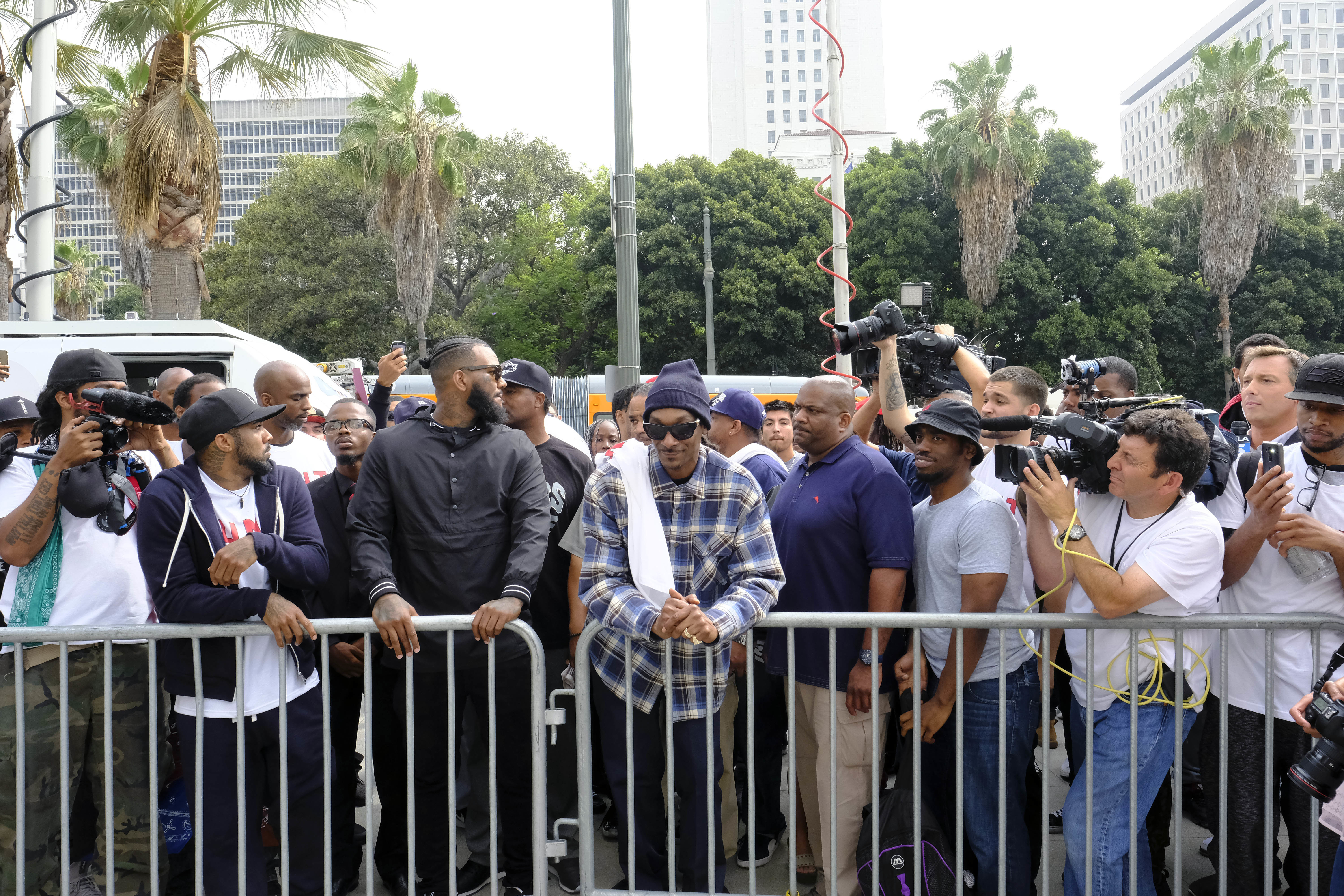 Rappers The Game, third from left, and Snoop Dogg, center, lead a march in support of unification outside of the graduation ceremony for the latest class of Los Angeles Police recruits in Los Angeles, Friday, July 8, 2016, after the shooting deaths of multiple police officers in Dallas on Thursday night. (AP Photo/Richard Vogel)