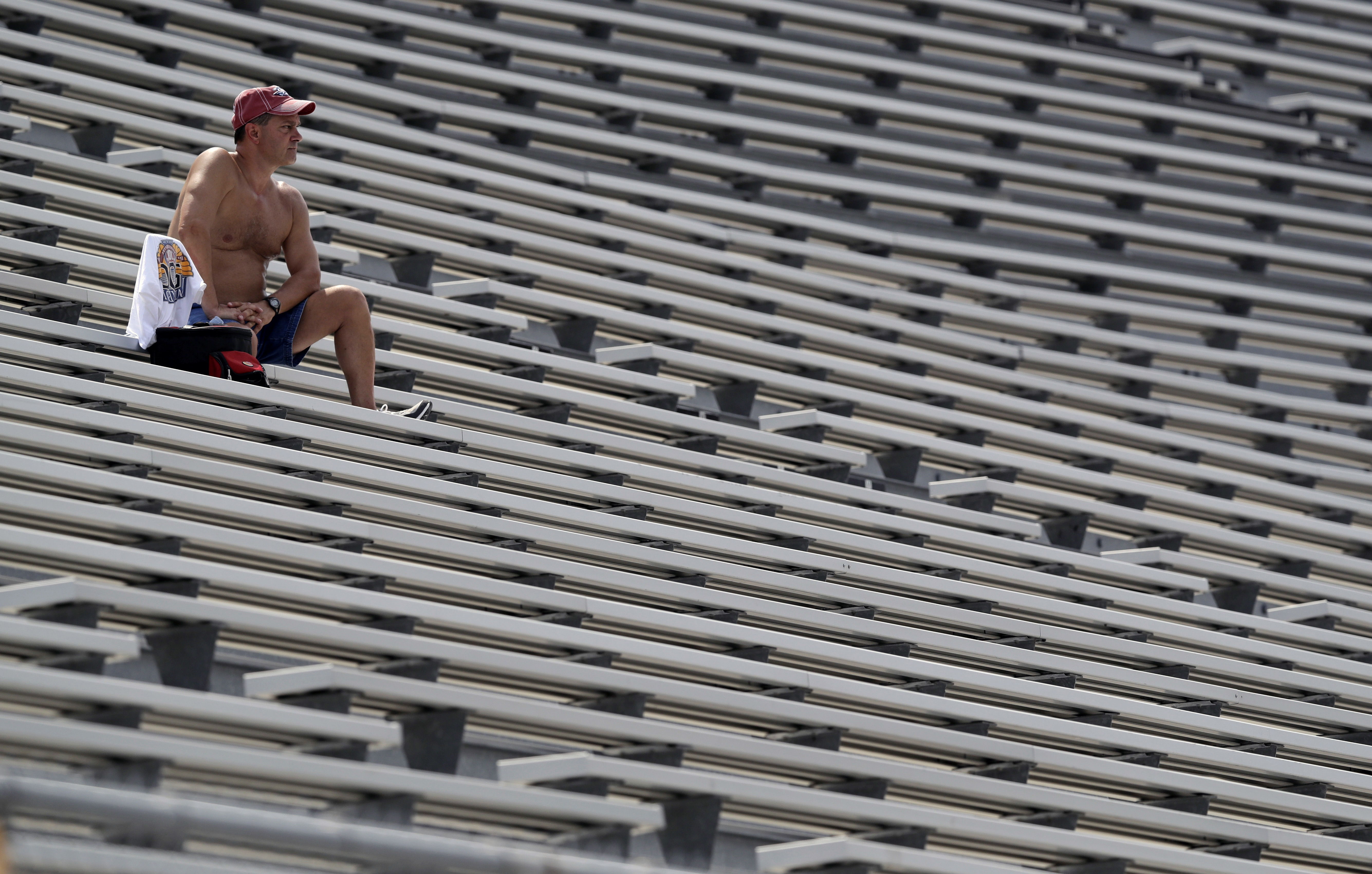 A fan watches from the stands as temperatures climb to the mid 90s with a heat index over 100 during the running of the Brickyard 400 NASCAR auto race at Indianapolis Motor Speedway in Indianapolis, Sunday, July 24, 2016. (AP Photo/Michael Conroy)