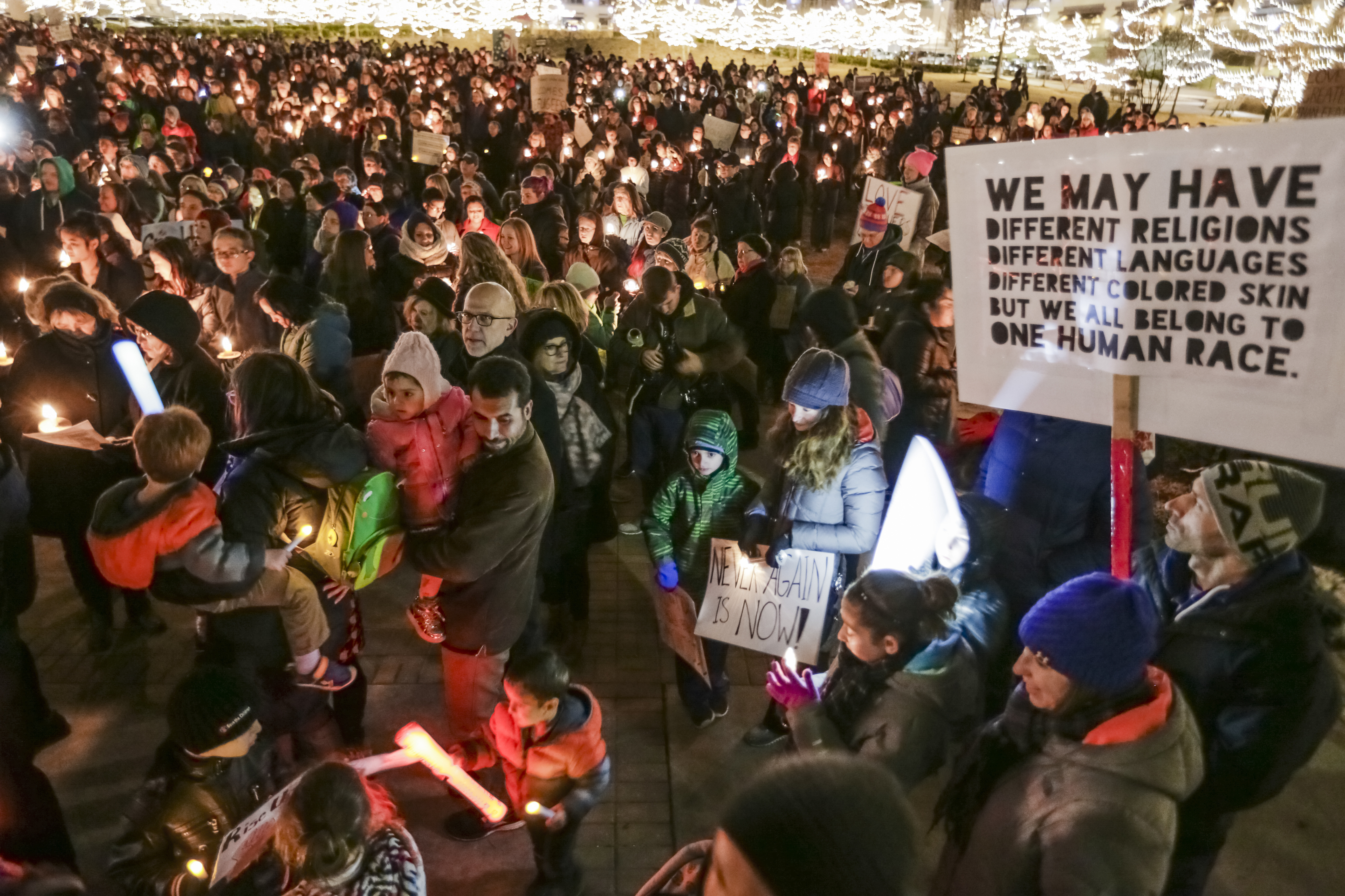 Participants gather with signs during a multi-faith candle light vigil in support of refugees and immigrants, held Tuesday, Jan. 31, 2017, in Omaha, Neb. (AP Photo/Nati Harnik)
