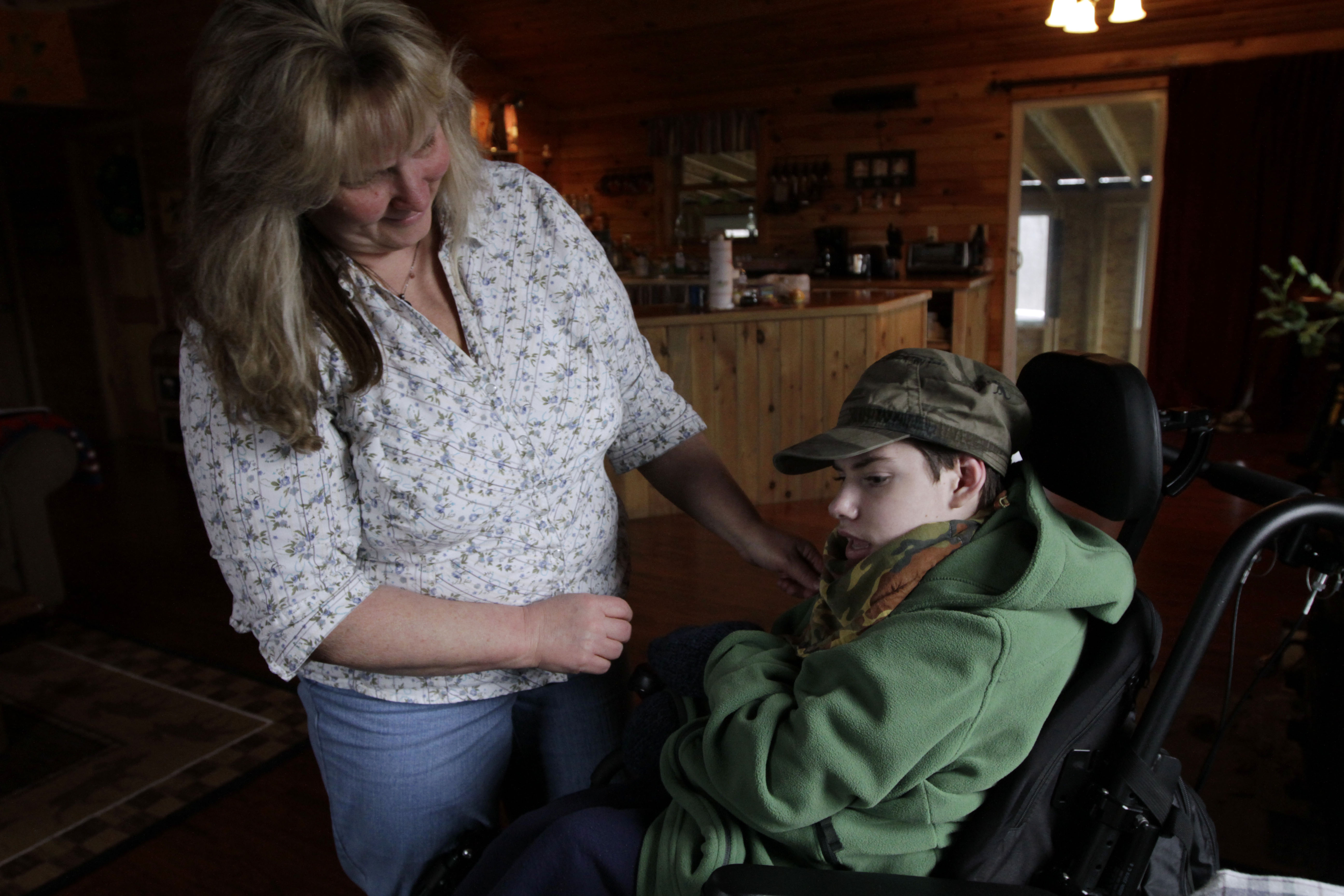 Ethan Kelly, age 21, who has cerebral palsy, gets help from his mother. AP File Photo/Pat Wellenbach.