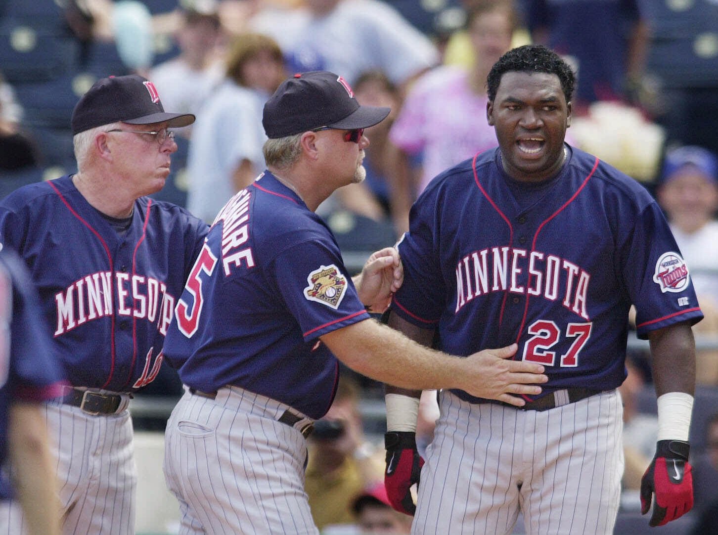 Minnesota Twins' David Ortiz, right, is moved toward the dugout by manager Tom Kelly, left, and third base coach Ron Gardenhire, center, after being ejected for arguing strike calls with plate umpire Paul Schrieber during a 2001 game in Kansas City. Photo: Ed Zurga | Associated Press