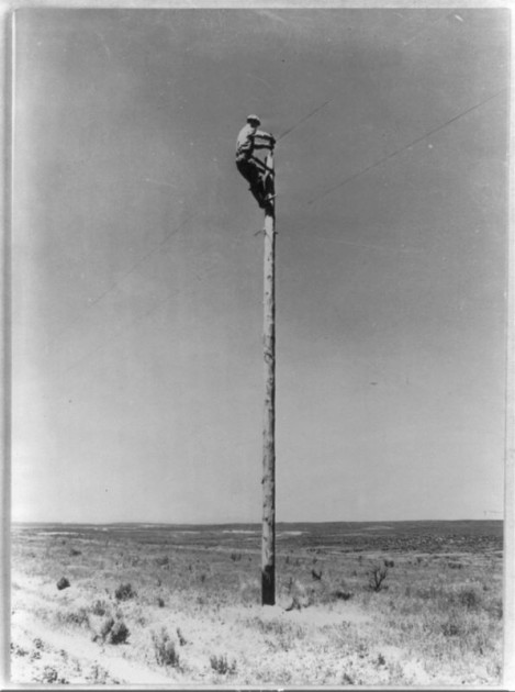 A lineman from the Rural Electrification Administration hangs a power line. (Photo courtesy of the Library of Congress)