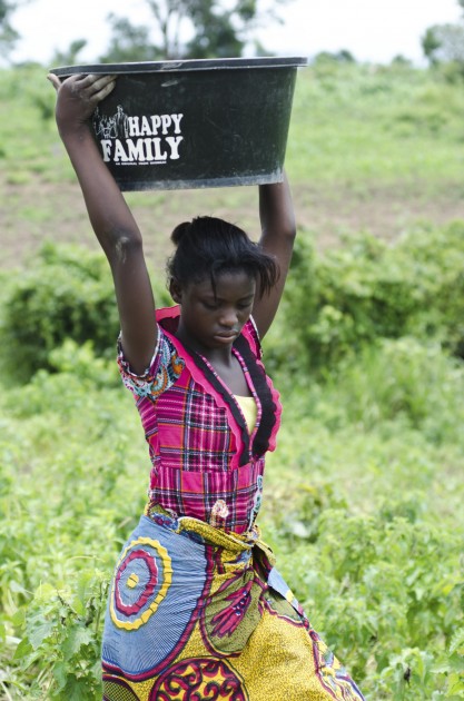 Dorothy Sule carries a tub of peanuts on the Sule family farm outside of Kuje, Nigeria on Monday.